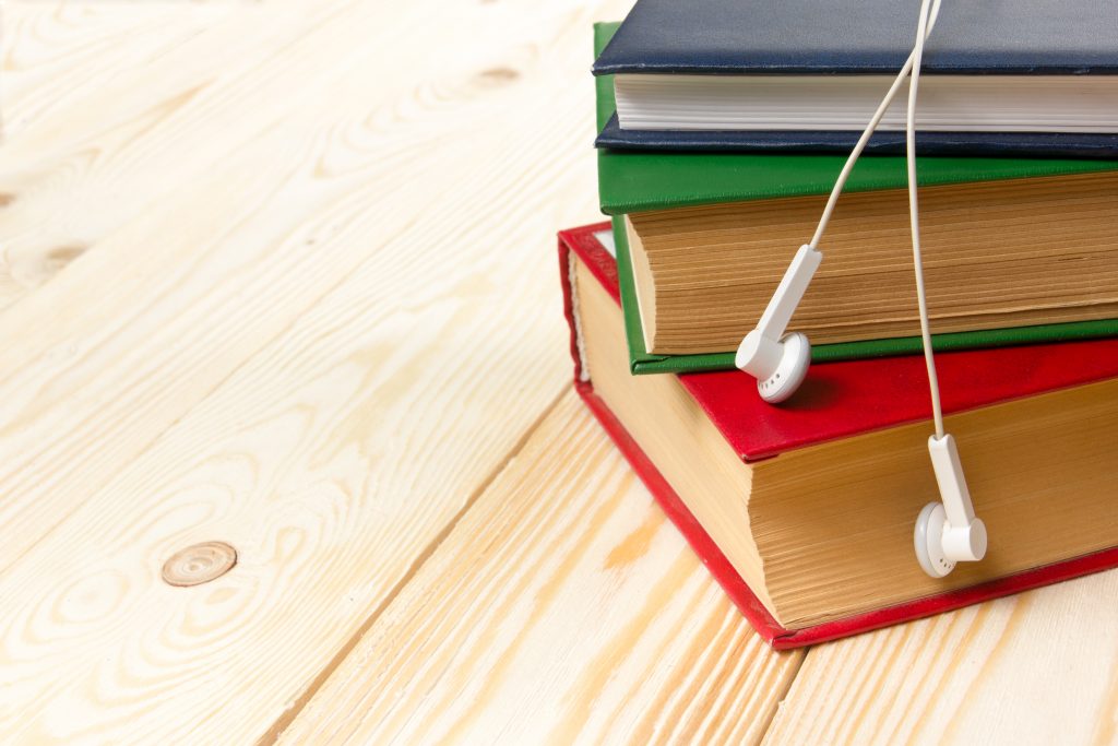 A stack of books with earphones