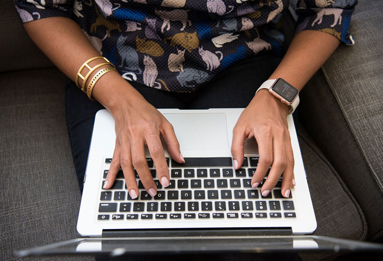 A person typing on their laptop